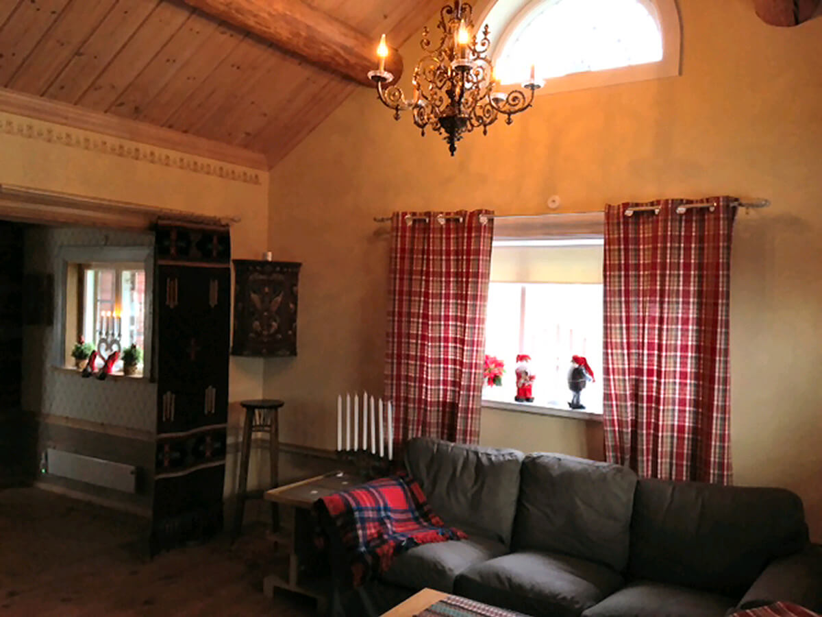 Storstugan med vackert lunettfönster / Main cabin with high ceilings and a beautiful old chandelier